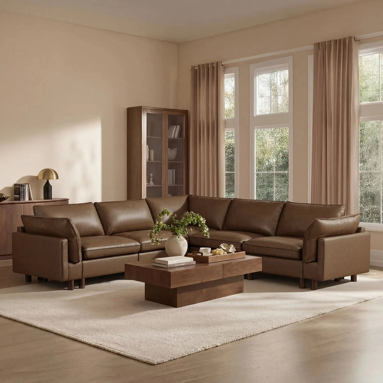 Brown leather L-shaped sectional with a wood coffee table in a bright living room