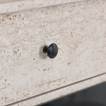 Close-up of a black round knob on a beige travertine fireplace sideboard.