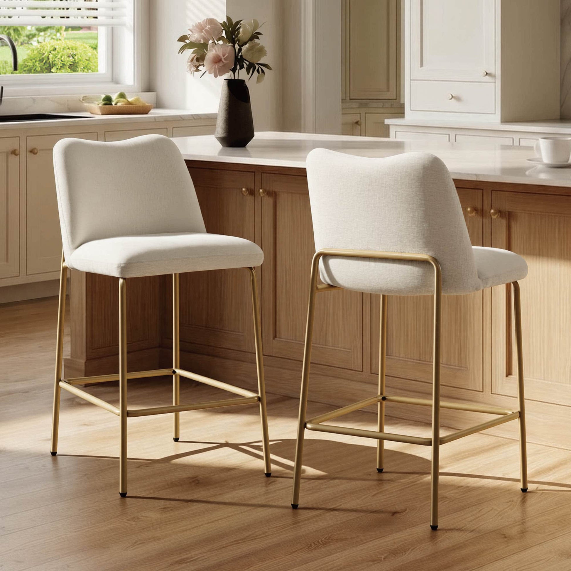 White upholstered barstools with gold metal base in a modern kitchen