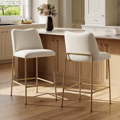 White upholstered barstools with gold metal base in a modern kitchen