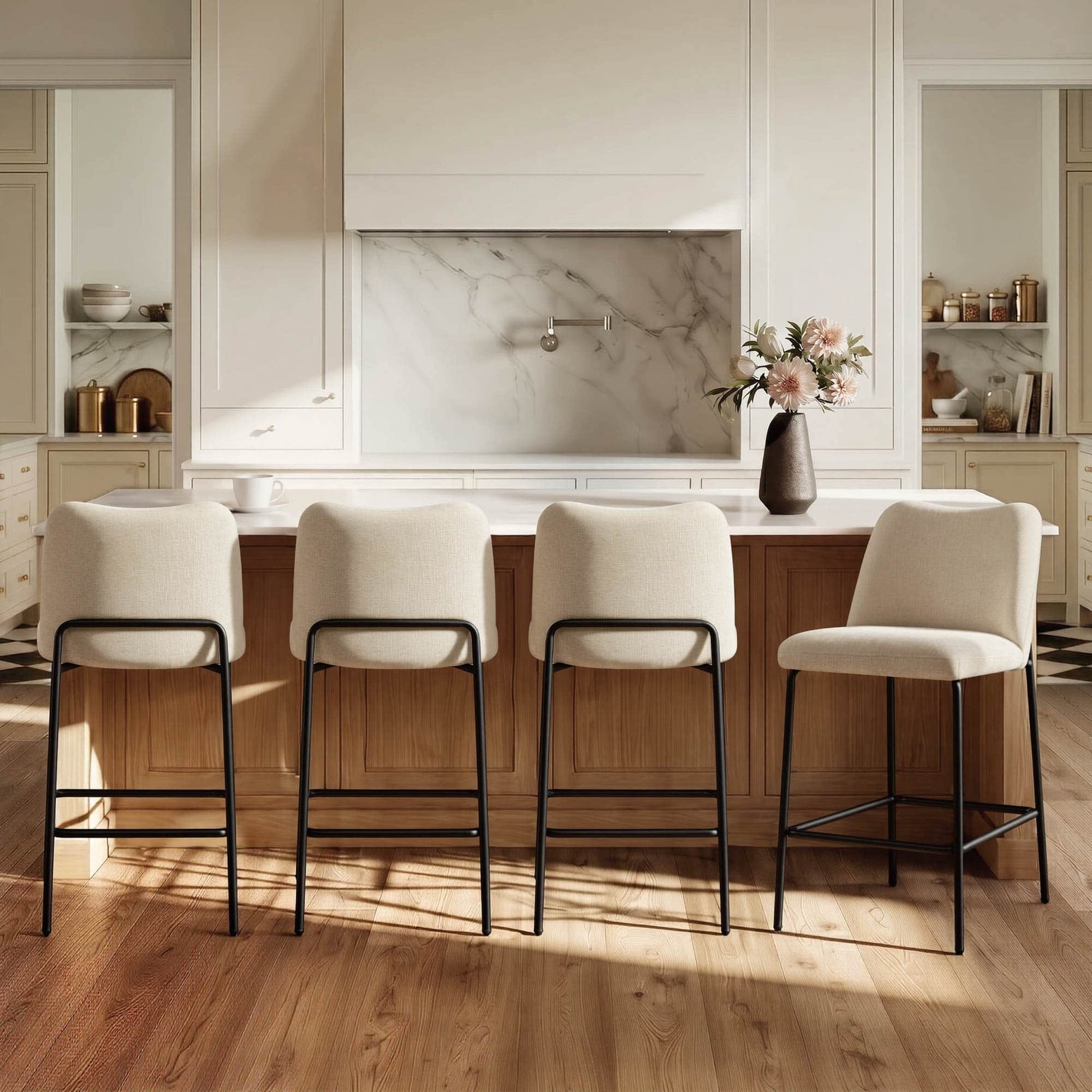 Four cream upholstered barstools with black metal bases in a modern kitchen
