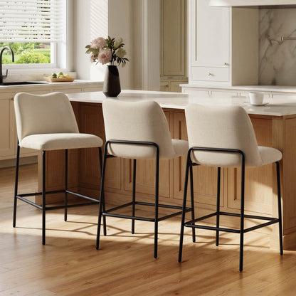 Modern beige upholstered barstools with black metal bases at a kitchen island