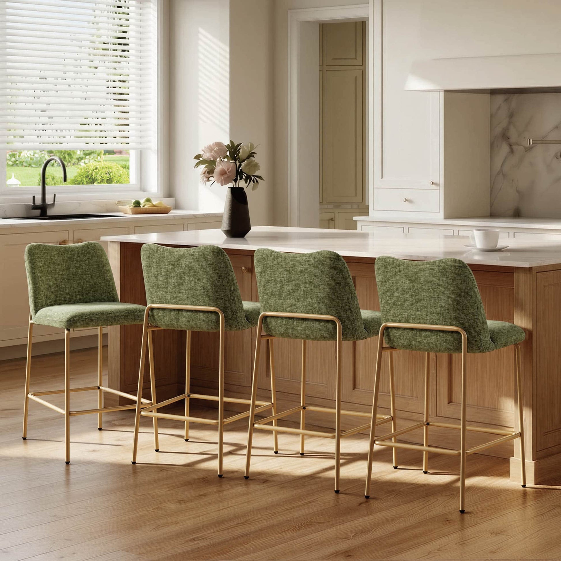 Green upholstered barstools with gold metal bases beside a kitchen island