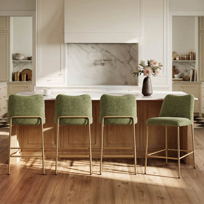 Green upholstered Amalia modern metal base barstools with gold frames at a kitchen island