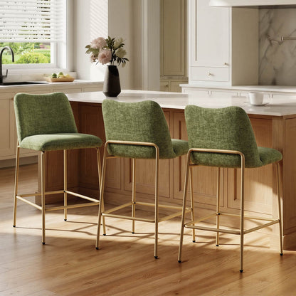 Green upholstered metal base barstools with gold legs at a kitchen island
