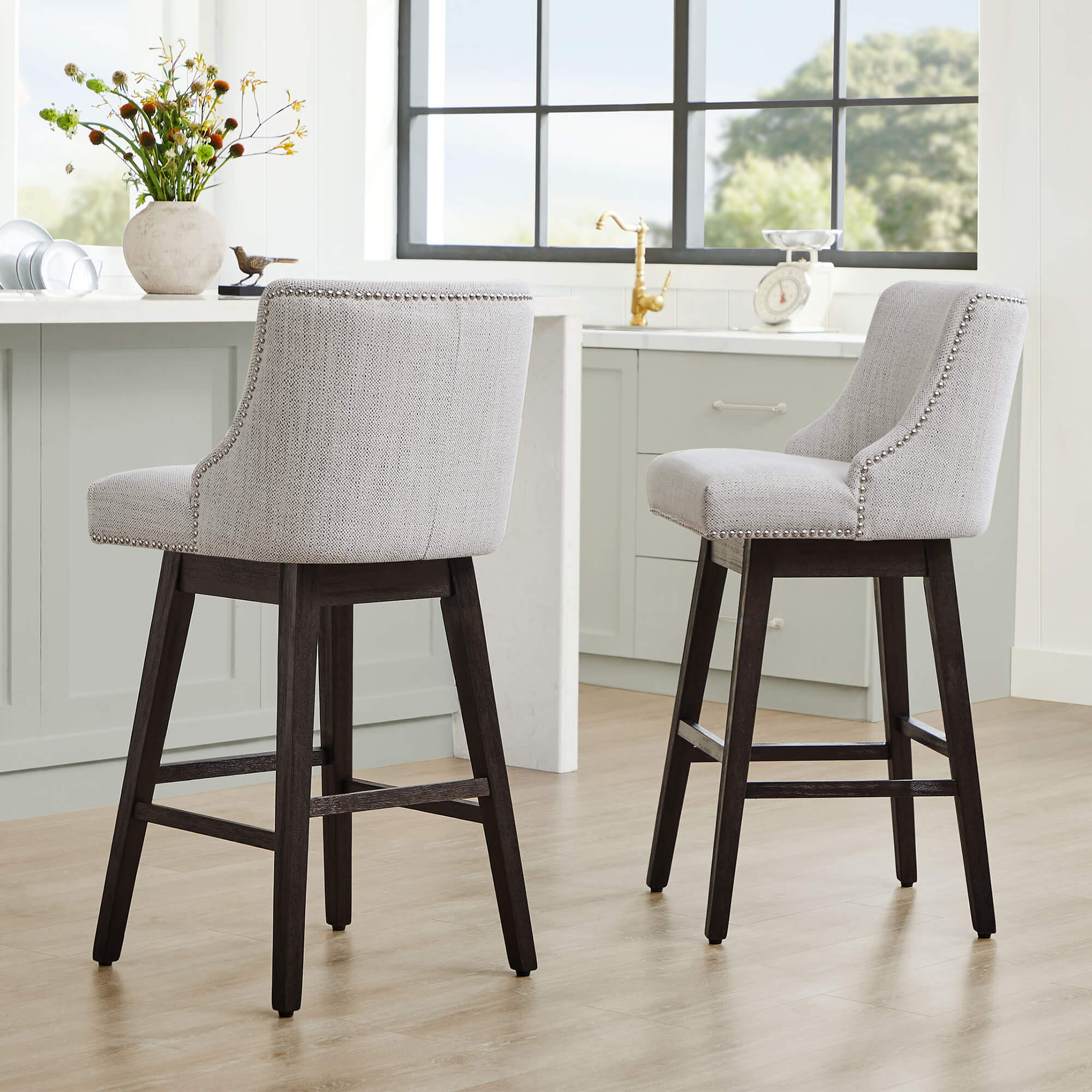 Asher swivel bar stools in light gray upholstery with silver nailhead trim in modern kitchen - CHITA Living