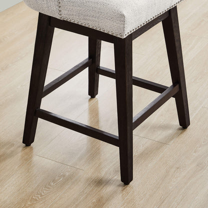 Close-up of sturdy wooden legs and footrest of Asher swivel stool with nailhead trim - CHITA Living