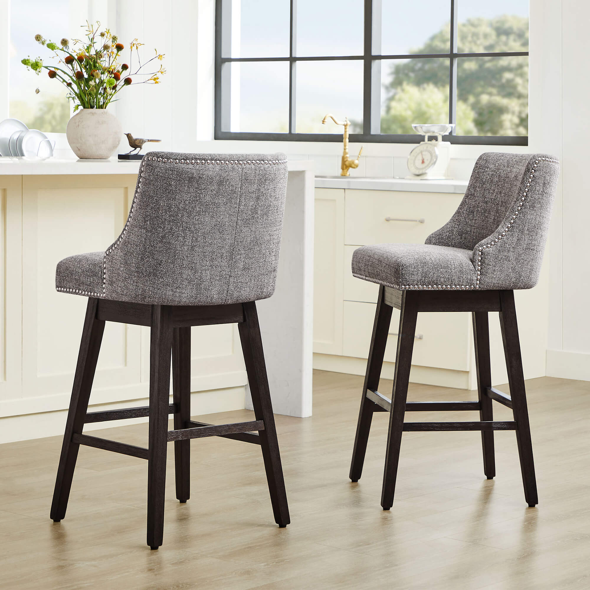 Asher gray swivel bar stools with silver nailhead trim in modern kitchen setting - CHITA Living