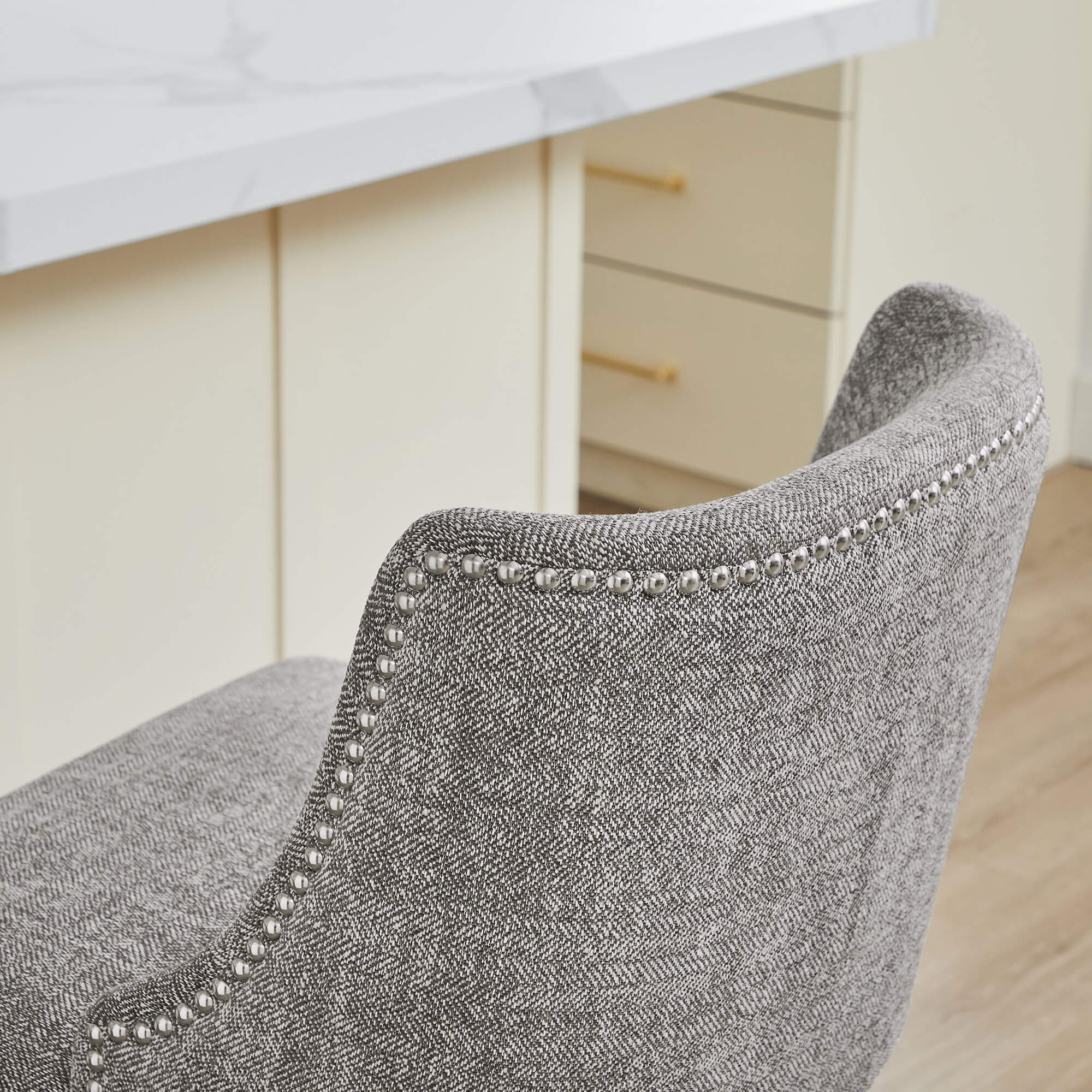 Close-up of Asher swivel stool in gray upholstery with nailhead trim detail - CHITA Living