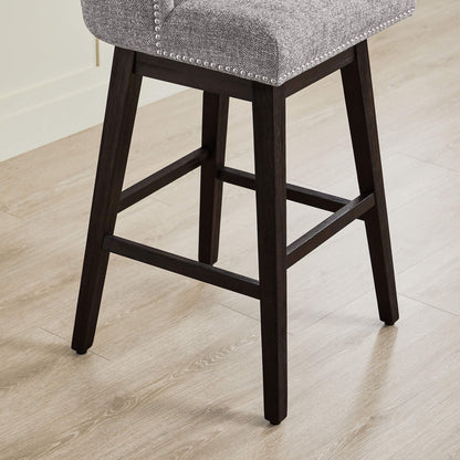 Asher swivel bar stool close-up highlighting nailhead trim and dark wooden legs - CHITA Living