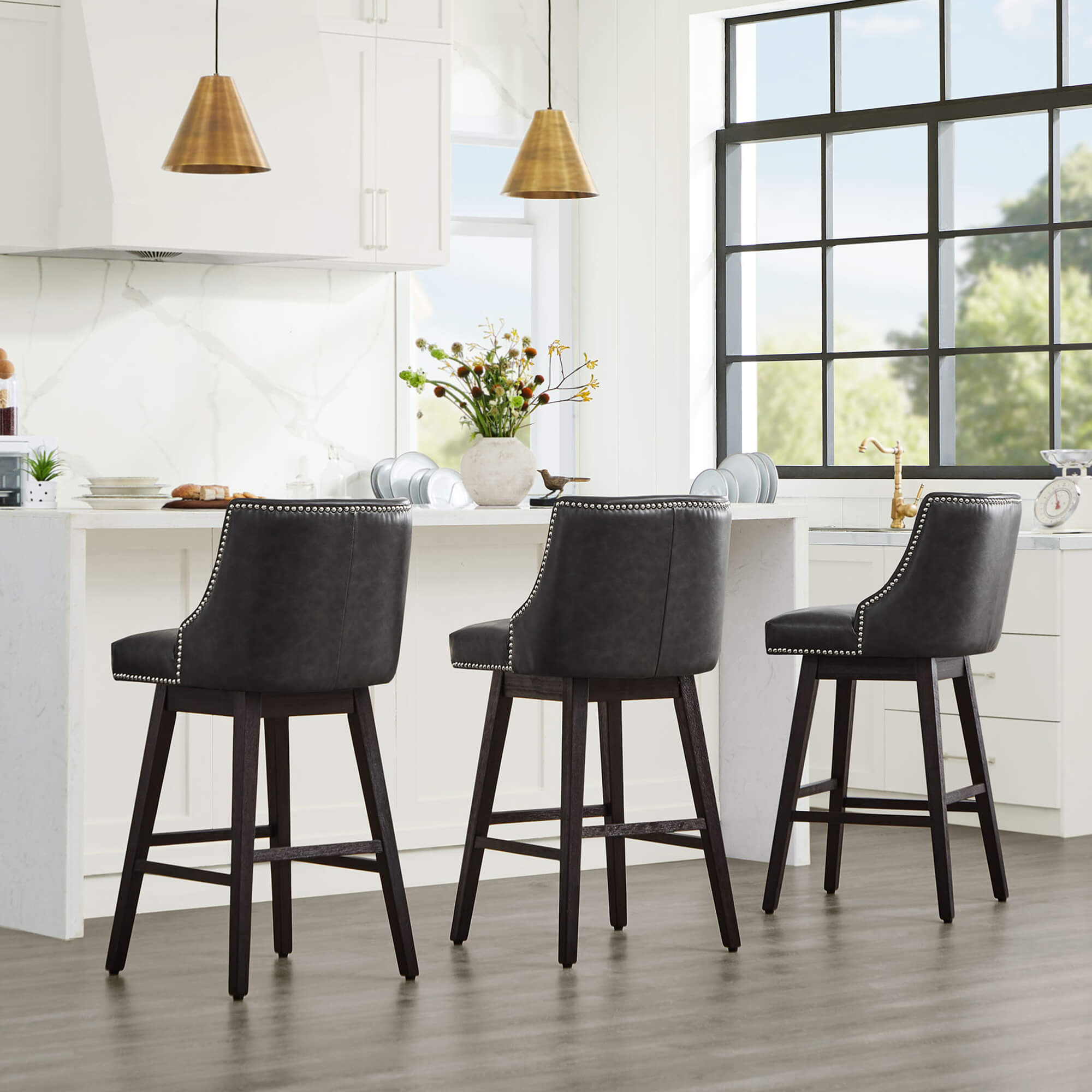 Dark gray Asher swivel bar stools with silver nailhead trim in a modern kitchen setting - CHITA Living