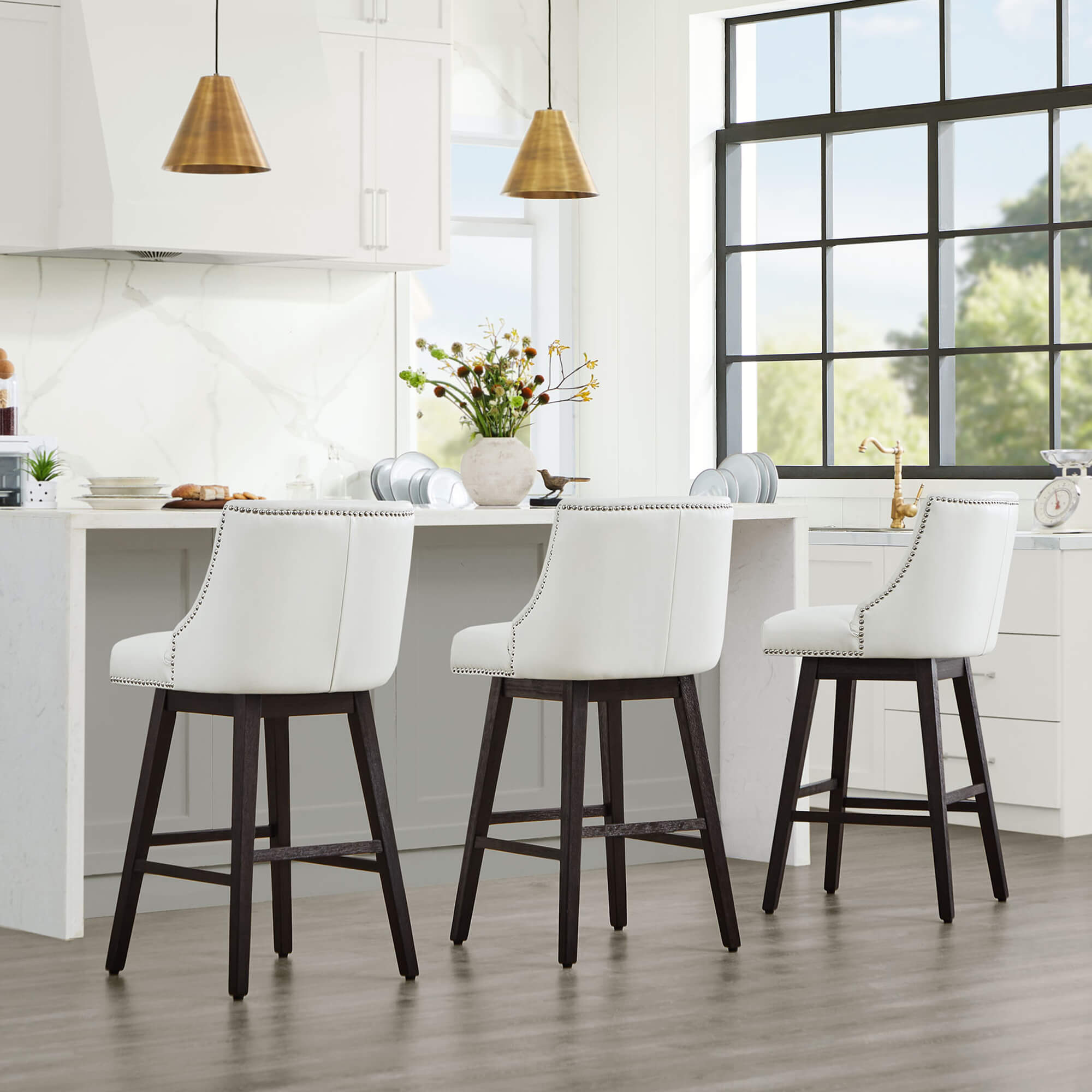 White Asher swivel bar stools with nailhead trim at modern kitchen island - CHITA Living