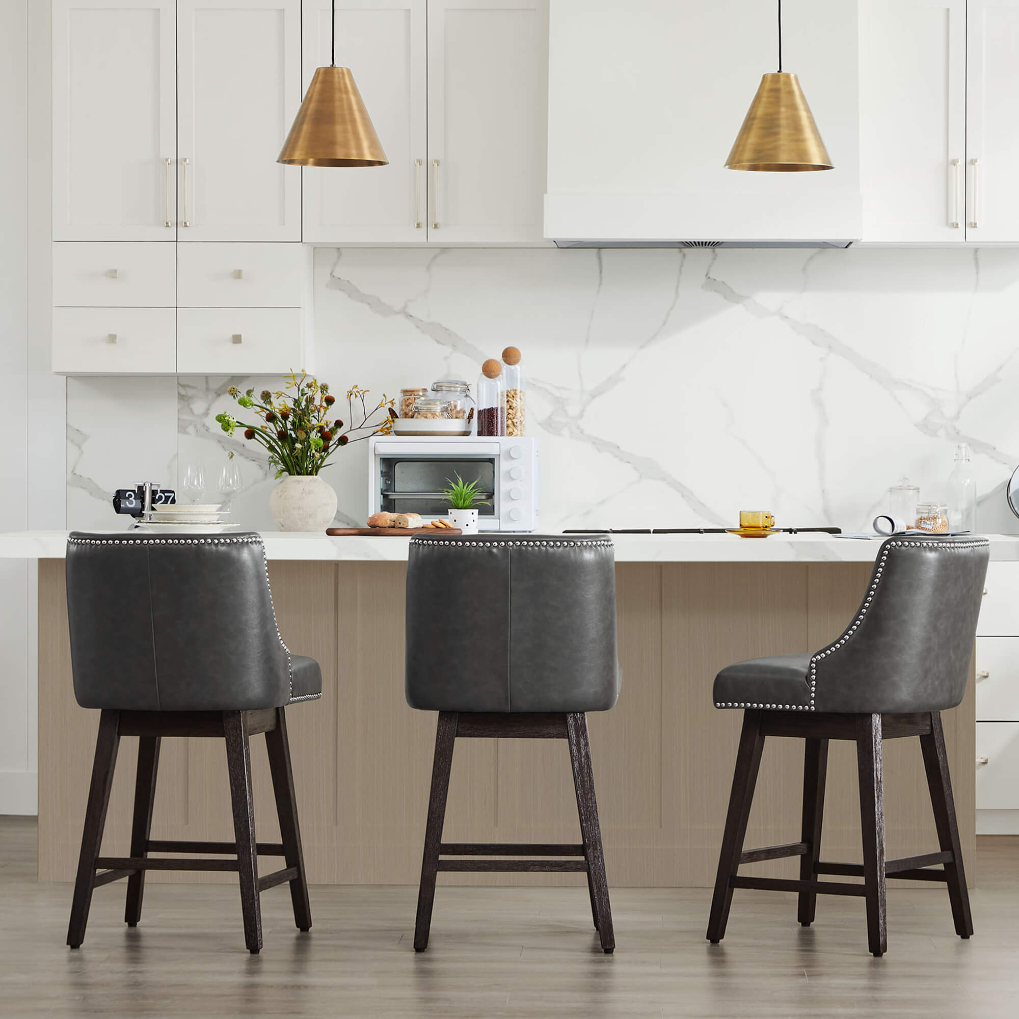 Gray Asher swivel bar stools with silver nailhead trim at a modern kitchen island - CHITA Living