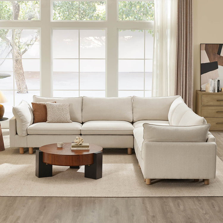 Cream fabric Brendon modular corner sectional sofa with wood legs and plush cushions in a bright living room.