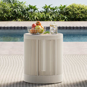 A Clover Acacia Wood Woven Outdoor Bistro Set side table with fruits and a drink by the pool.