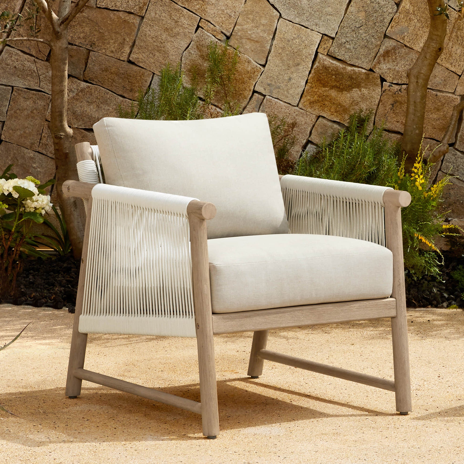A Sienna Modern Acacia Wood Woven Outdoor Bistro Set chair with light beige cushions