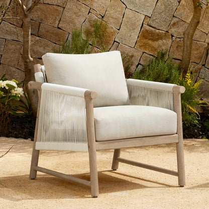 A Sienna Modern Acacia Wood Woven Outdoor Bistro Set chair with light beige cushions