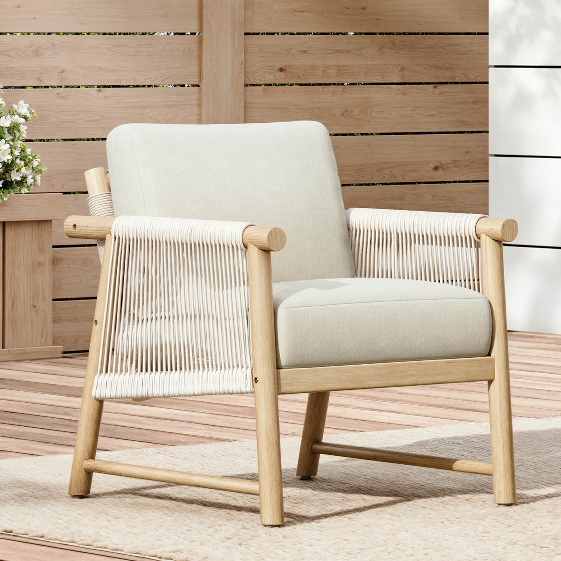 A Sienna Modern Acacia Wood Woven Outdoor Bistro Set chair with cream cushions on a patio.