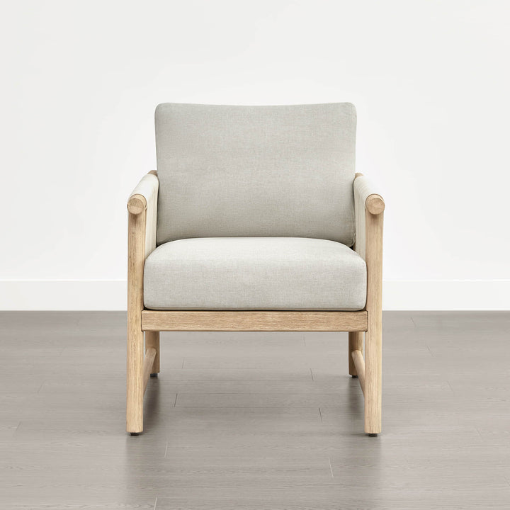 A Sienna Modern Acacia wood woven outdoor lounge chair with light beige cushions, set on a gray floor.