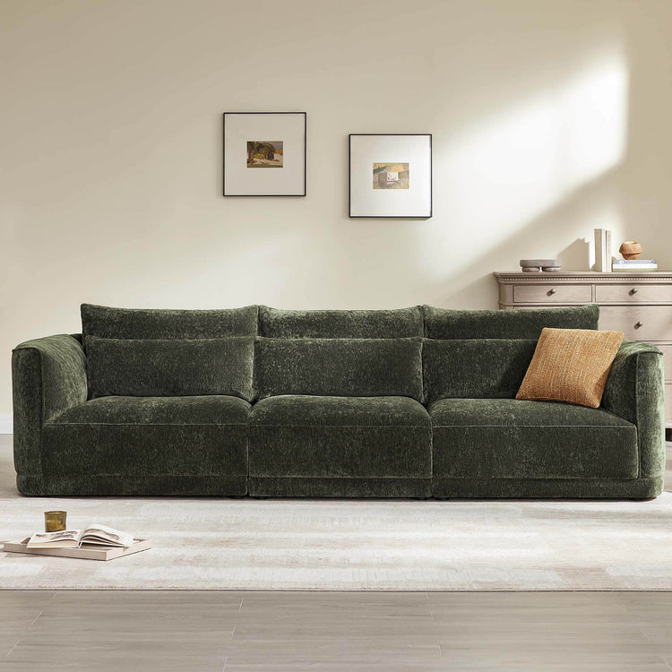 Daisy 3-seat modular curved chenille sofa in forest green with down-filled cushions and orange accent pillow.