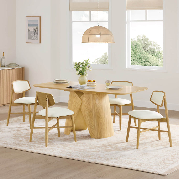 Elowen sculptural wood base dining table in walnut, featuring angled legs and four cream upholstered chairs.