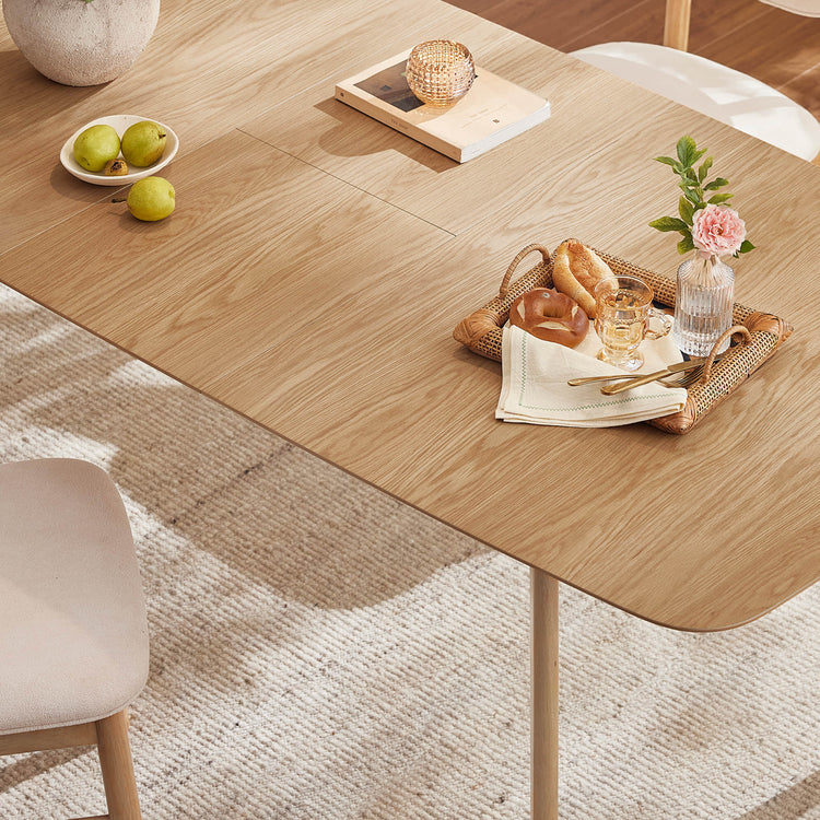 Hilda light oak extendable dining table with rounded corners, set for breakfast with pears and baked goods.