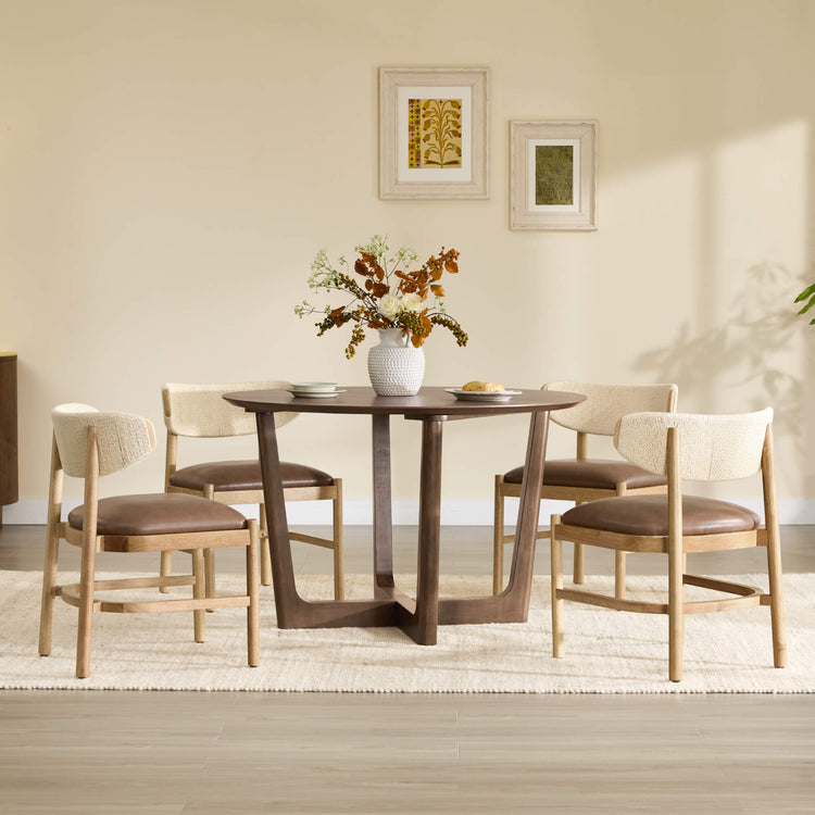 Jody chairs with woven rope backs and brown leather seats around a dark wood dining table.