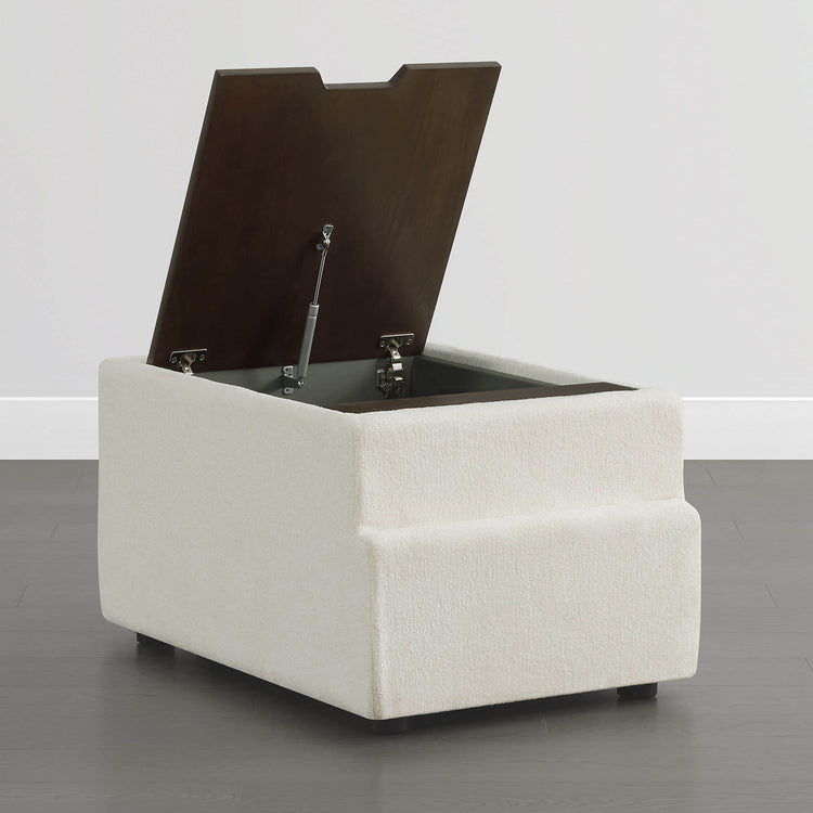 Cream boucle fabric storage ottoman with hinged dark wood lid and brass hinges.