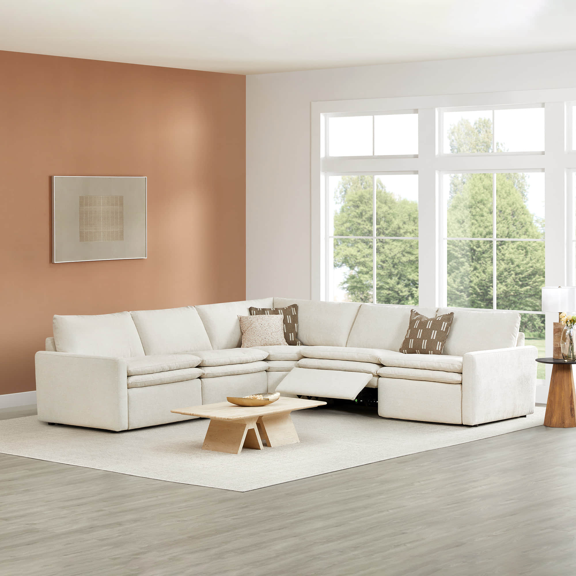 L-shaped Ohana 5-seat motion modular sofa in soft beige with plush cushions and large windows - CHITA Living