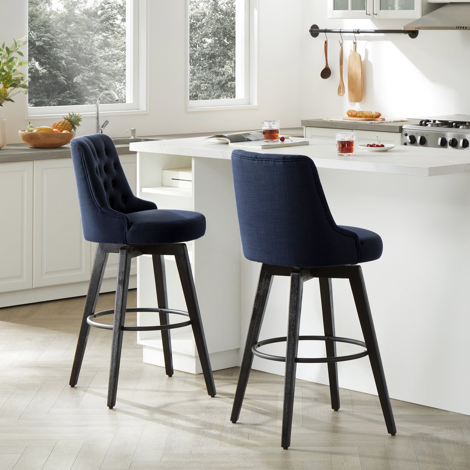 Navy blue tufted swivel bar stools with black wood legs in a modern kitchen setting - CHITA Living