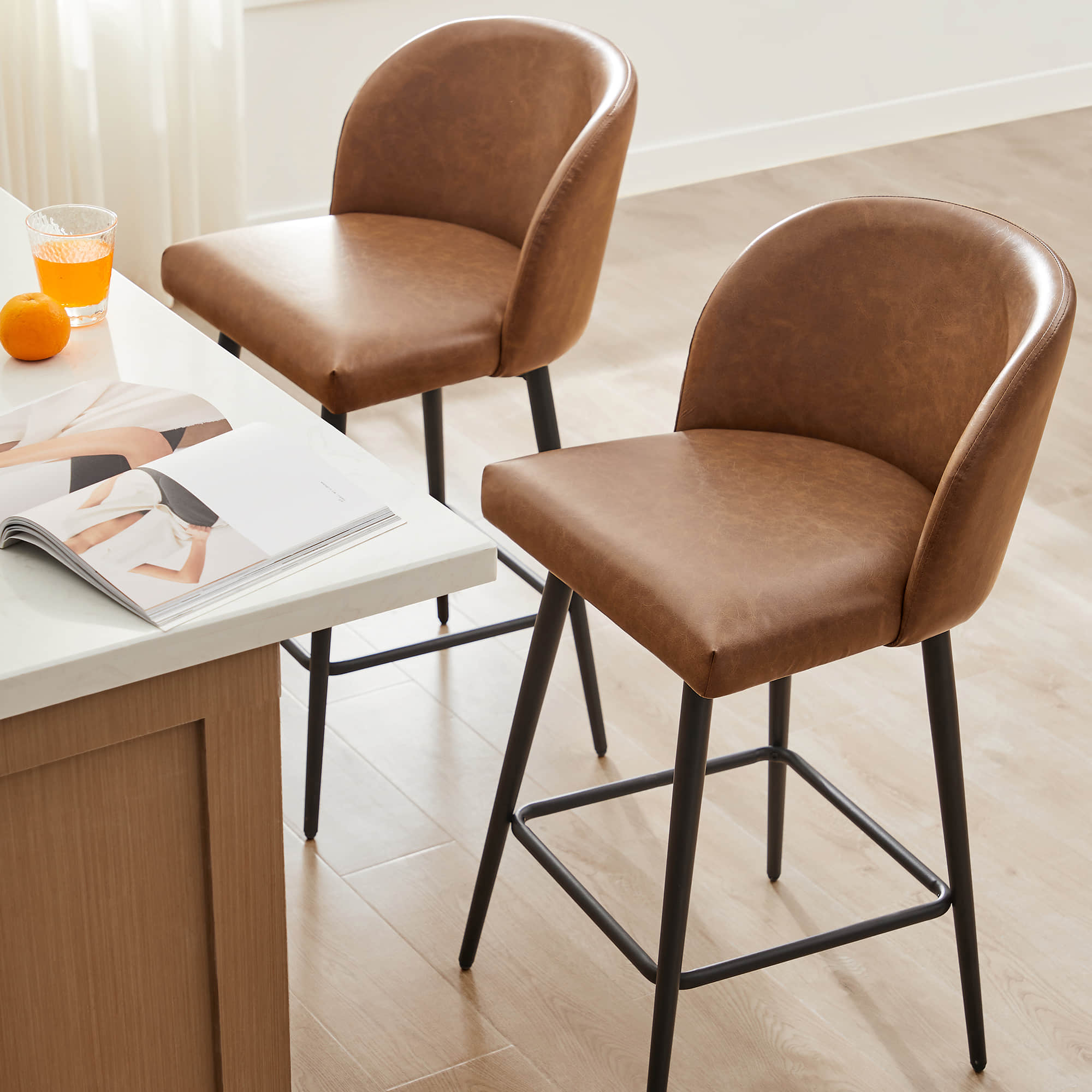 Set of two light brown Nova Swivel Bar Stools with rounded backs and black metal legs - CHITA Living