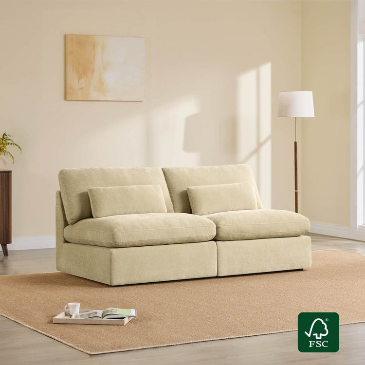 Beige modular armless sofa with plush cushions and lumbar pillows on a rug, featuring an FSC logo.
