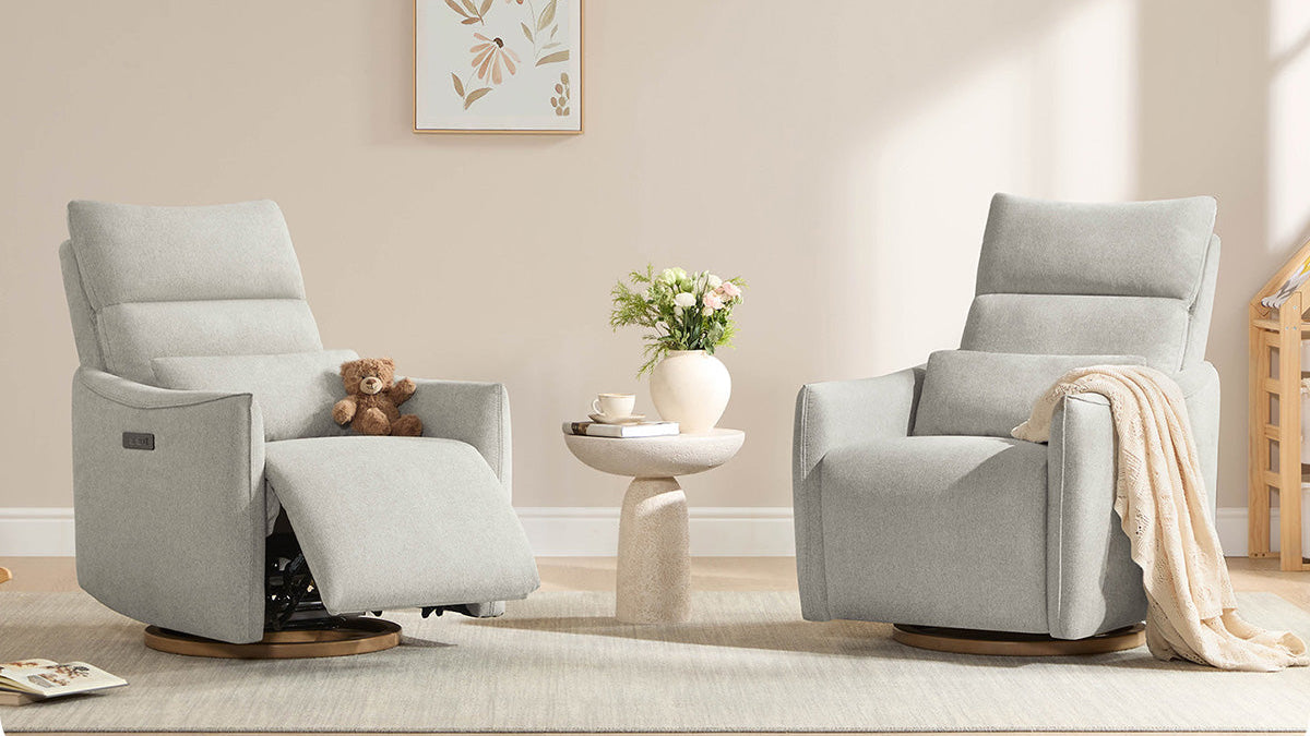 Two gray recliner chairs in a living room setting with a small table and decorative items.