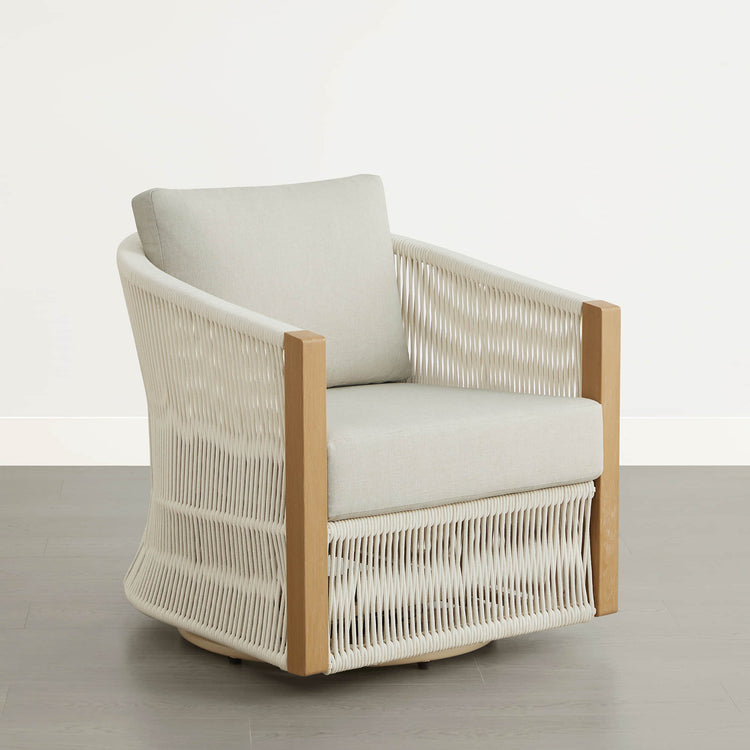 A woven outdoor swivel lounge chair with a light wood frame and cream cushions.