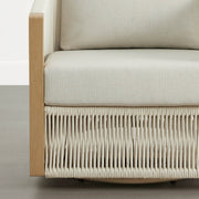 An outdoor bistro set chair with a cream cushion and woven base