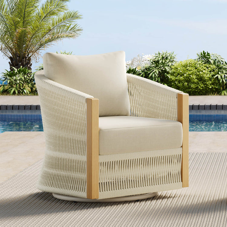 A woven outdoor swivel lounge chair with cream cushions, set beside a pool.