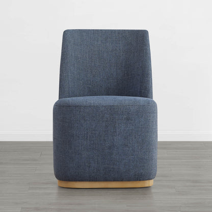 Modern blue upholstered dining chair with a wooden base in a minimalist setting - CHITA Living