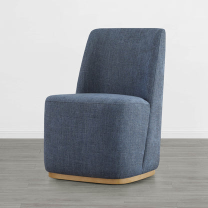 Blue upholstered dining chair with a curved base in a bright modern room - CHITA Living