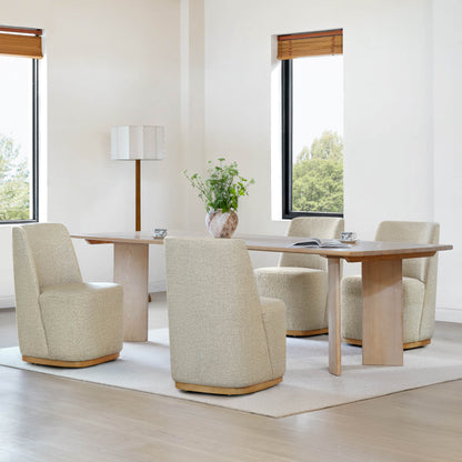 Beige textured wingback chairs around a light wooden dining table in a bright room - CHITA Living