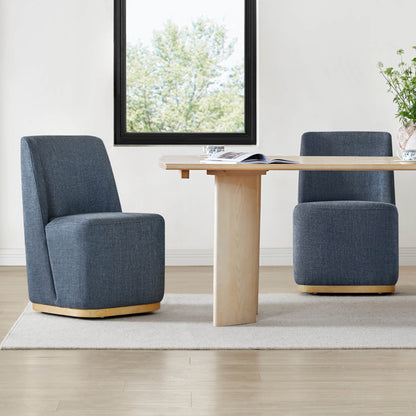 Blue upholstered wingback chairs around a light wooden dining table in a bright interior - CHITA Living