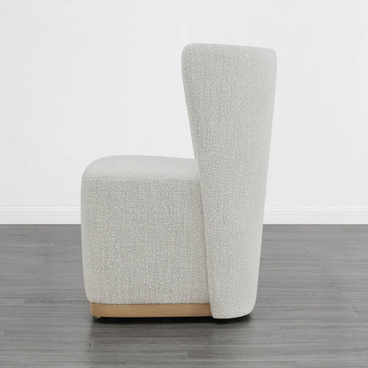 Cream textured wingback chair with curved design and wooden base in modern interior - CHITA Living