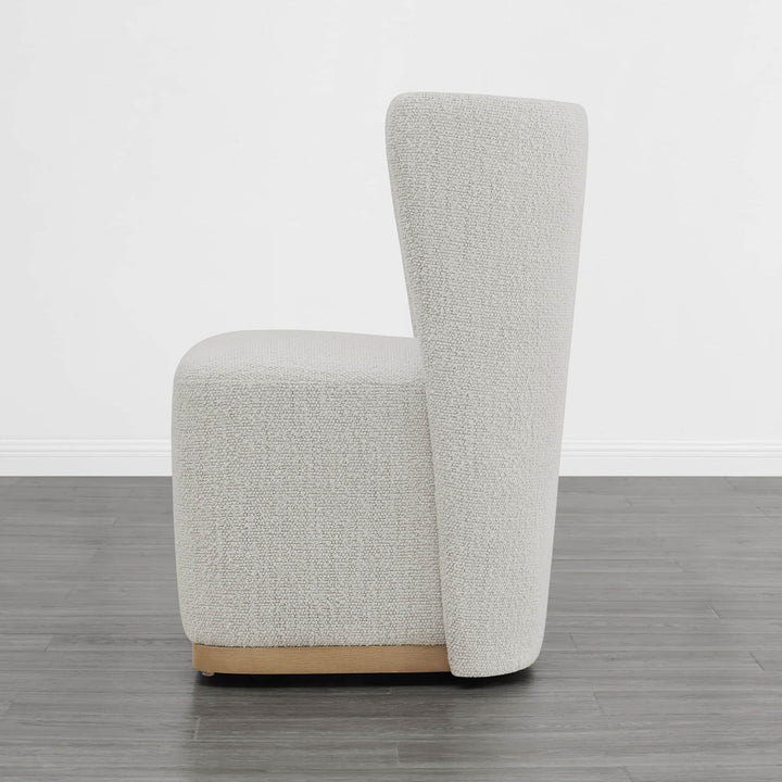 Cream textured wingback chair with curved design and wooden base in modern interior - CHITA Living