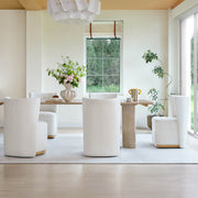 Cream upholstered wingback chairs around a light wooden dining table in a bright, modern room - CHITA Living