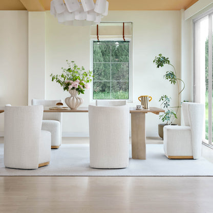Cream upholstered wingback chairs around a light wooden dining table in a bright, modern room - CHITA Living