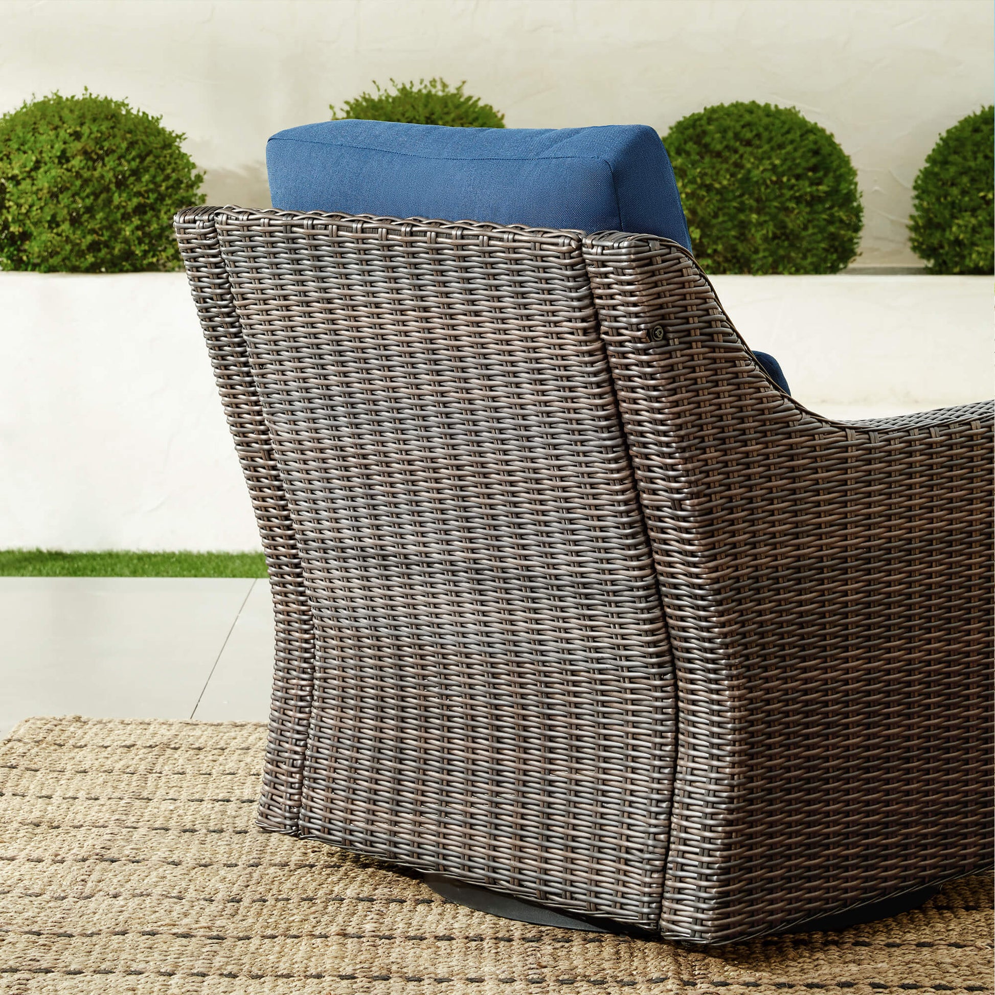 Back view of Elara Rattan chair with blue cushion, showcasing woven wicker design - CHITA Living