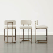 Three cream kitchen barstools, varied heights, studio setting.