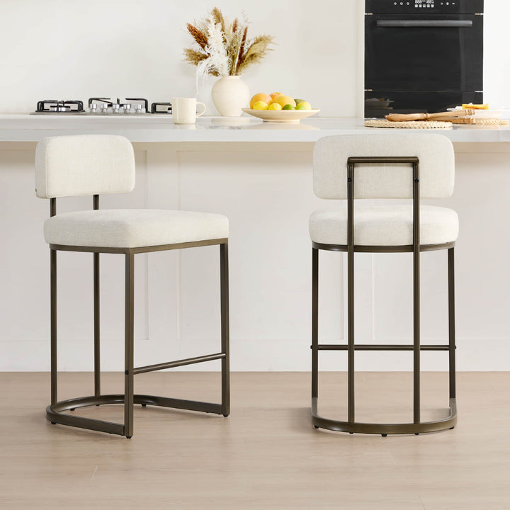Two cream fabric kitchen barstools at a bright kitchen counter.