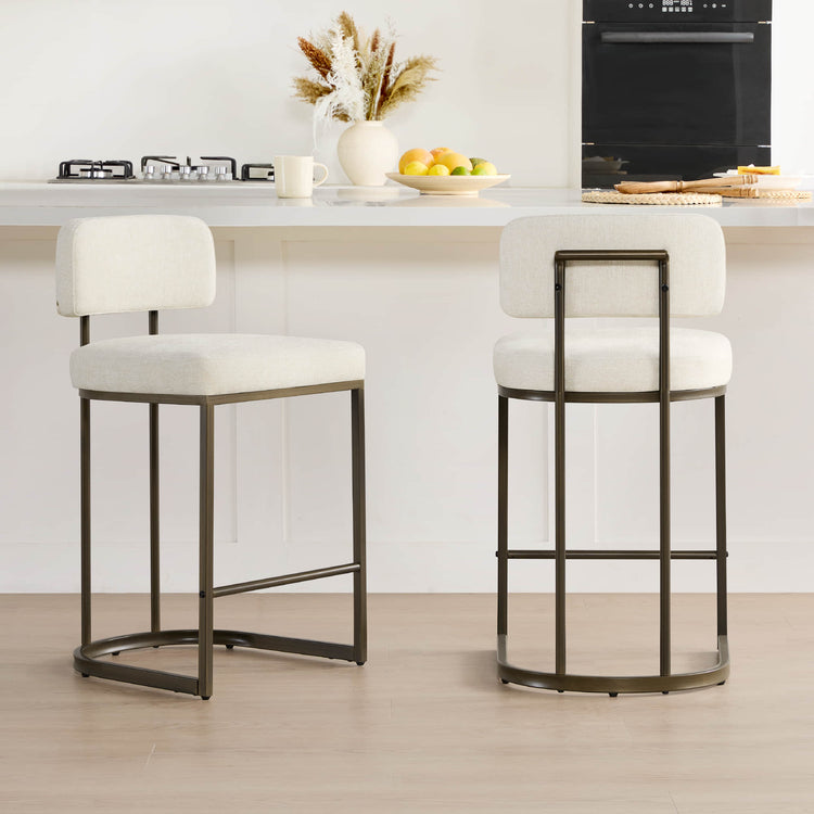 Two cream fabric kitchen barstools at a bright kitchen counter.