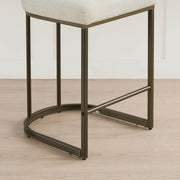 Detail: base of cream kitchen barstool, elegant dark metal legs.