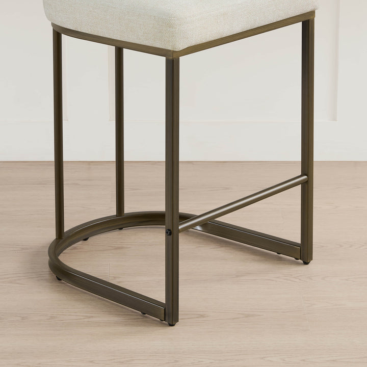 Detail: base of cream kitchen barstool, elegant dark metal legs.